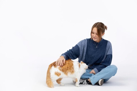 A joyful moment shows a woman petting her cat, highlighting their bond and the love between pets