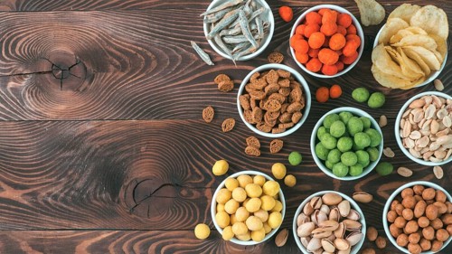 Assortment of different snack for beer, wine, party. Peanuts in coconut glaze, green vasabi, red