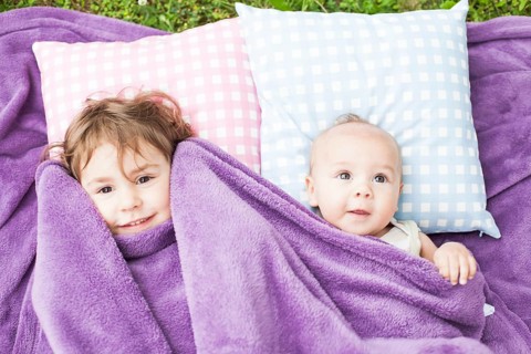 Sister and brother play on the pillows