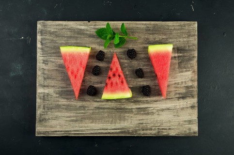 WATERMELON BLACKBERRY AND MINT ON THE BACKGROUND. THREE PIECES OF RIPE JUICY WATERMELON WITH RIPE