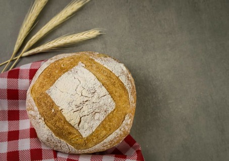 Beautiful Sourdough bread on gray background with dried wheat flower