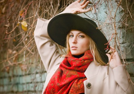Beautiful young blond woman with long hair flying in the wind wearing hat in park