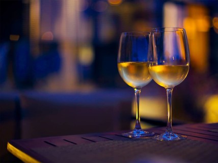 Two glasses of the white wine in the night. Close up. DOF