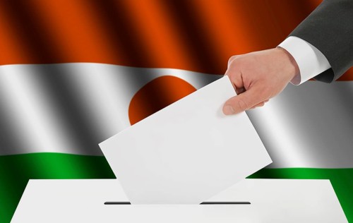 The Niger flag and the hand with the bulletin about the ballot box