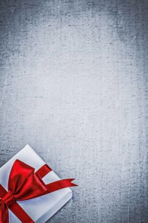 Present with red bow on metallic background copyspace holidays concept