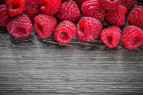 Raspberries on wooden background top view
