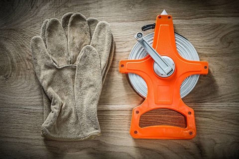 Safety gloves measuring tape on wooden board