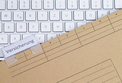 The photo shows a white keyboard with an insurance file folder