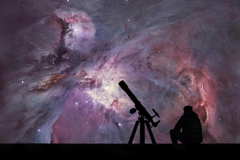 Man with telescope looking at the stars. The Orion Nebula Messier 42 diffuse nebula in