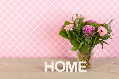 Colorful pink and purple bouquet in glass vase in interior