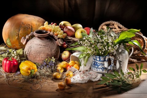 Still life with fruits, vegetables and tableware on a wooden table