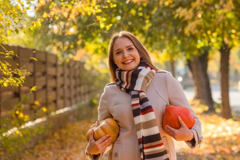 Portrait of happy smile woman with pumpkins in hand. Cozy autumn vibes Halloween, Thanksgiving day