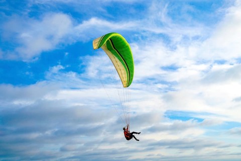 Man doing sport, Para-glider in the clouded sky. Paragliding is an extreme sport and recreation.