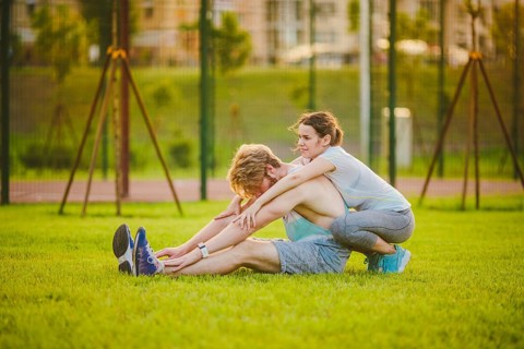Young in love heterosexual Caucasian couple, man with beard woman with big breasts doing exercise