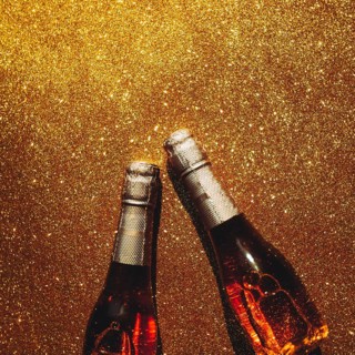 Christmas or New Year composition with bottles of rose champagne on golden shiny background, top