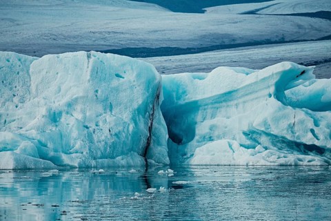 Large ice formations in a serene icy landscape with reflections on water, iceberg, glacier, snow,
