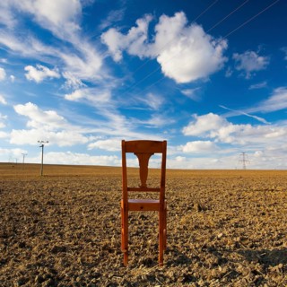 Old wooden chair on the empty field after harvest