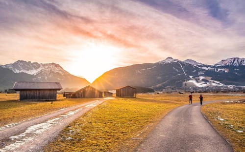 Winter landscape with mountain village in the Austrian Alps, wooden barns and country roads, at