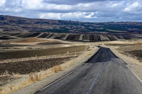 On the way to Fes, Morocco, A winding country road stretches through a hilly landscape surrounded