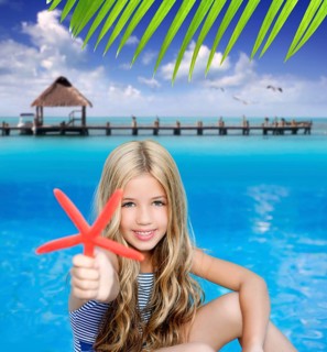 Children blond girl in summer vacation tropical beach with starfish
