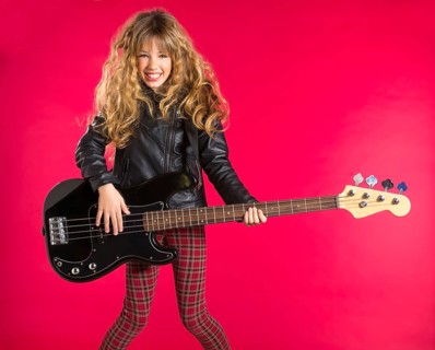 Blond Rock and roll girl playing bass guitar on red background