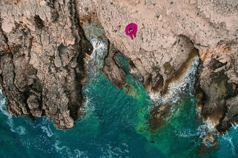 A girl in a purple dress rests on a rocky beach in Montenegro, aerial photography, Herceg Novi,