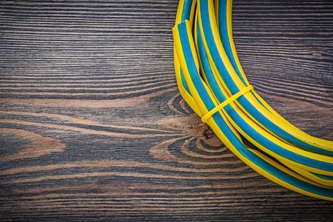 Coiled rubber hose on wooden board gardening concept