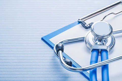 Stehoscope and clipboard on blue background medical concept