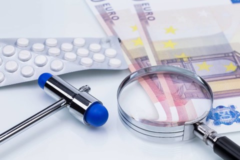 The photo shows a pack of tablets with a magnifying glass and money