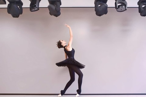 Young ballet dancer black swan practicing before performance in black tutu, classical dance studio,