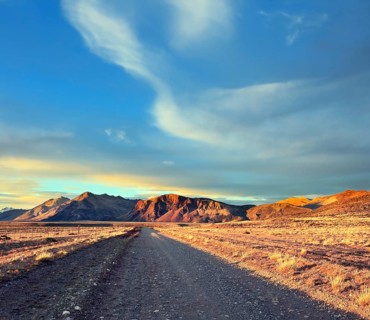 Argentine Patagonia. The gravel road between the endless pampas. The setting sun illuminates the