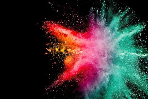 Abstract multicolored powder explosion on black background. Color dust particle splattered on