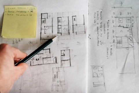 Man architect drawing plan or design by pencil on paper at office desk