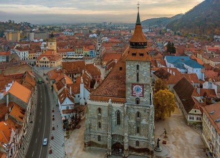 Aerial view of Brasov old town with Black Church and Piata Sfatului square in autumn morning,