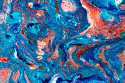 The background is acrylic blue with red lines and sparkles. Colourful marble texture. Liquid, fluid