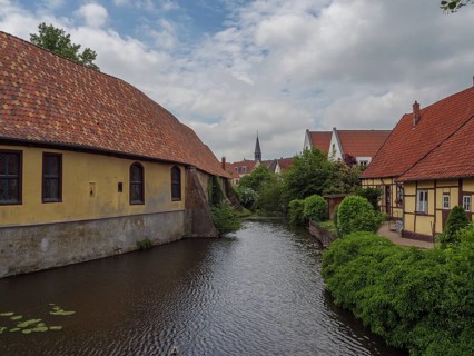 Historic half-timbered houses along a quiet river in dense vegetation, steinfurt, münsterland,