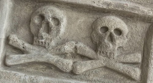 Ancient stone skull with crossbones. Old sculpture. Ideal for concepts and backgrounds