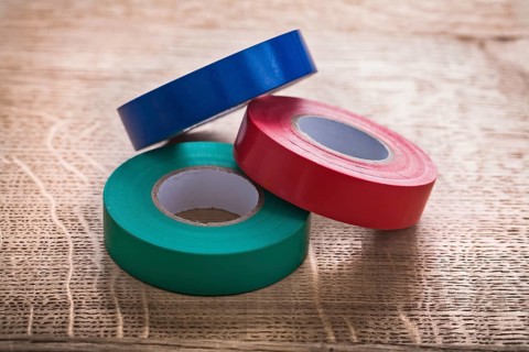 Three rolls of insulating tape on wooden board construction concept