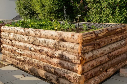 Planted raised bed made from rustic tree trunks