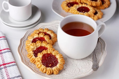 Cookies with jam and a cup of tea served for breakfast