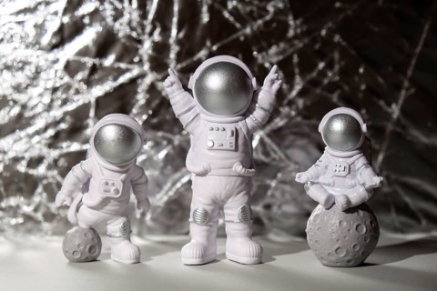 Three Plastic toys figure astronaut on silver background Copy space. Concept of out of earth