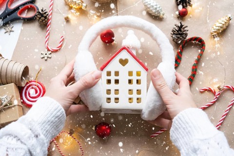 Cozy house in Christmas decor layout, warm knitted scarf, hat, winterization. Winter, snow, home