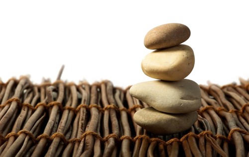 Stacked stones on wooden base. White isolated
