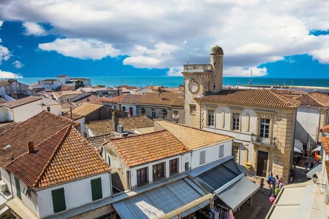 Orange and yellow tiled roofs of Provencal city Saintes-Maries-de-la-Mer. Mediterranean Sea. The