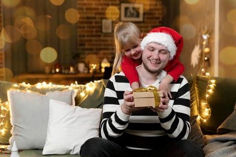 Merry Christmas and Happy New Year. Christmas gift surprise. A little smiling daughter girl hugging