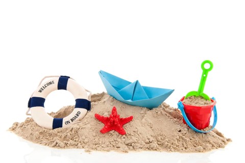 Beach with life buoy and toys in the sand isolated over white background