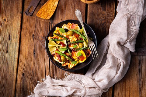 Pasta salad with green asparagus, olives and Parma ham