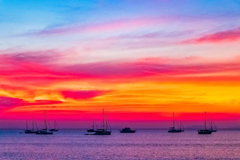 Yachts boats in front of the most beautiful colorful sunset at Tropical Paradise island Koh Phayam