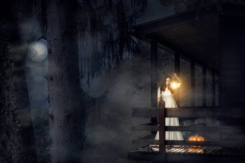 Spooky girl, in a white dress, holding a lit lantern, a pumpkin near her, on the balcony of a