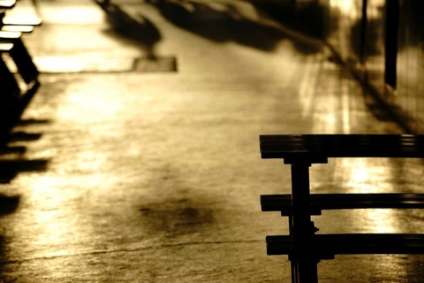 Gold-coloured light reflections in a corridor or passageway of a shopping street with shadows and
